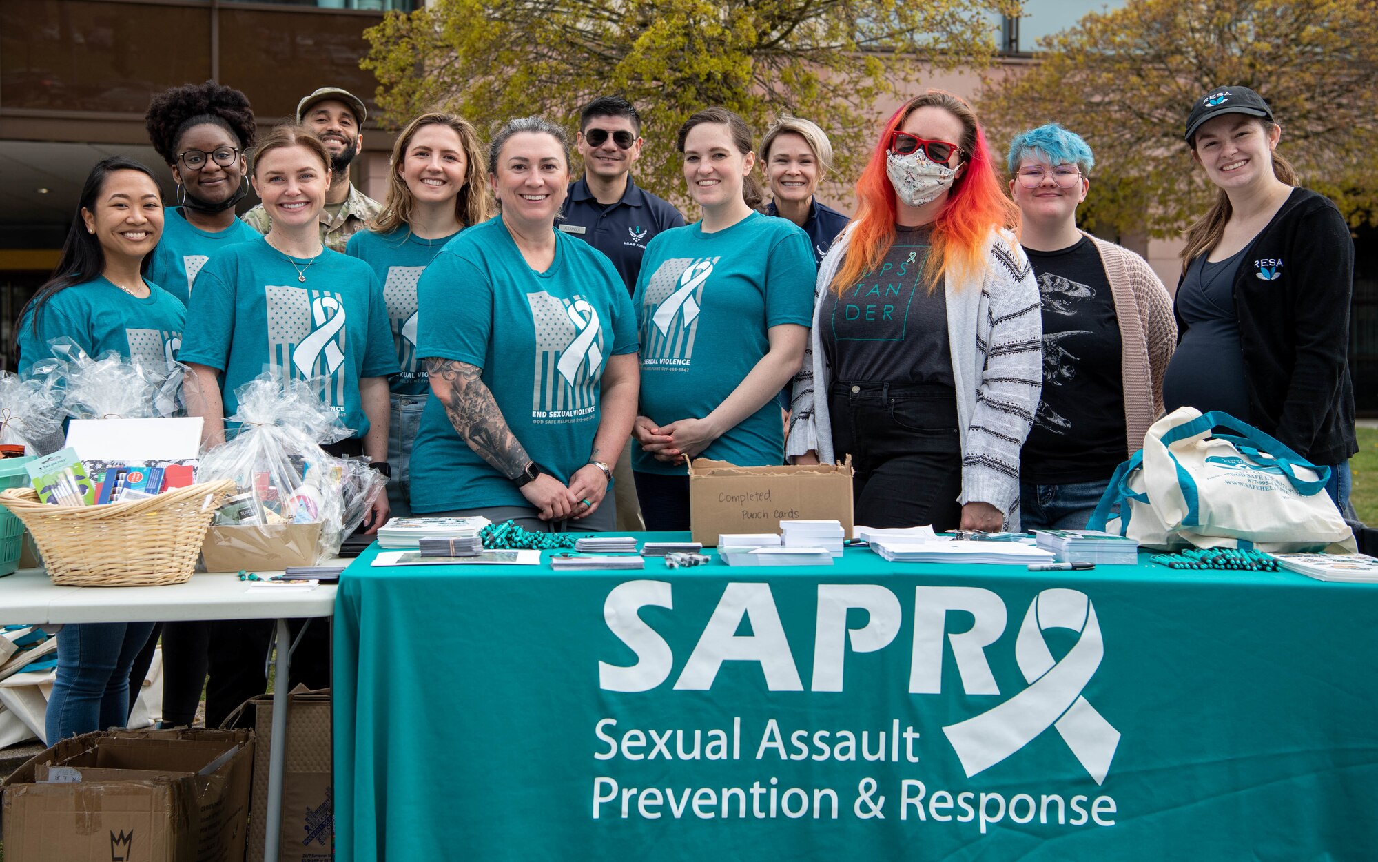 Group of women stand at table for Sexual Assault Prevention & Response
