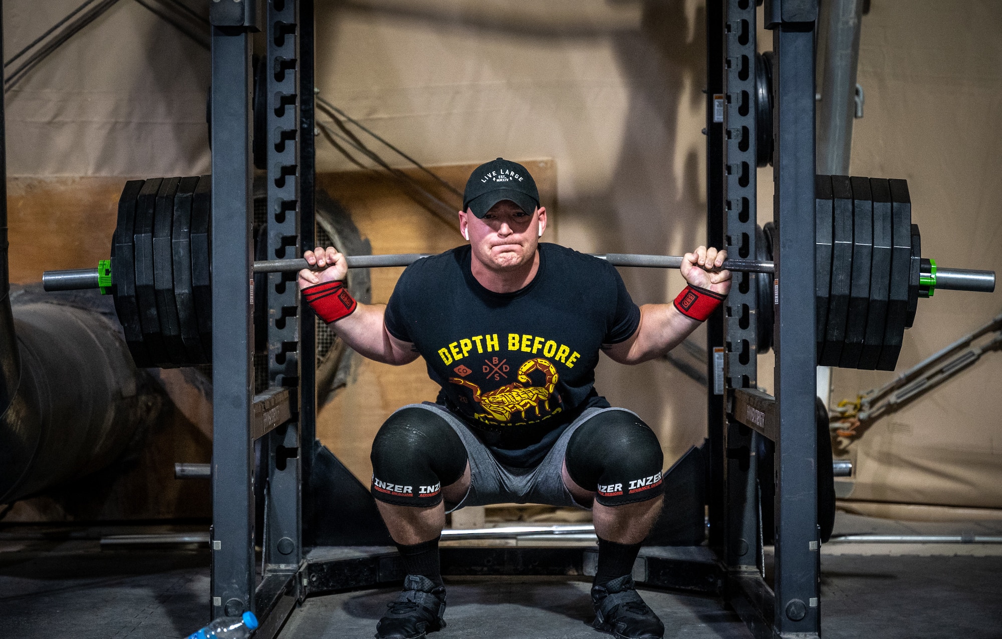 Tech. Sgt. Adam Angus, 332d Expeditionary Contracting Squadron non-commissioned officer in charge of future plans, back squats 515 pounds at the Legends Fitness Center at an undisclosed location in Southwest Asia, April 24, 2022. Angus uses powerlifting as a means to push his limits, both in lifting and in life. “Powerlifting lets me push my limits and see how far I can go, and this, in turn, pushes me to improve other areas of my life,” added Angus. (U.S. Air Force photo by Master Sgt. Christopher Parr)