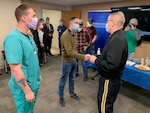 Brig. Gen. Tim Covington, the Wisconsin National Guard’s deputy adjutant general for civil support, presents a coin to 2nd Lt. Jonathon Jennings for his leadership as a platoon leader of Wisconsin National Guard nursing assistants supporting health care facilities during a ceremony at the Mayo Clinic in La Crosse April 26, 2022. The Wisconsin National Guard is winding down its nursing assistant support mission around the state.