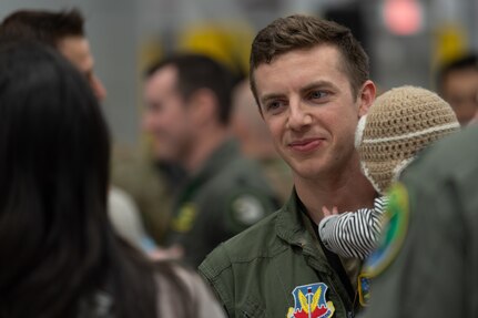 U.S. Air Force Capt. Zachary Smith, a fighter pilot assigned to the 315th Fighter Squadron, 158th Fighter Wing, holds his child prior to his departure from the Vermont Air National Guard Base, South Burlington, Vermont, Thursday, April 28th, 2022. The ceremony recognizes the sacrifices of Airmen and their families ahead of the 158th fighter wing’s deployment to Europe. (U.S. Air Force photo by Tech. Sgt. Richard Mekkri)