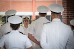 Navy Lieutenant Sarah Cruz, center, stands in front of a formation of officers during a Service Dress White Uniform inspection Friday, April 29.  Cruz and the officers serve aboard Naval Health Clinic Cherry Point.
