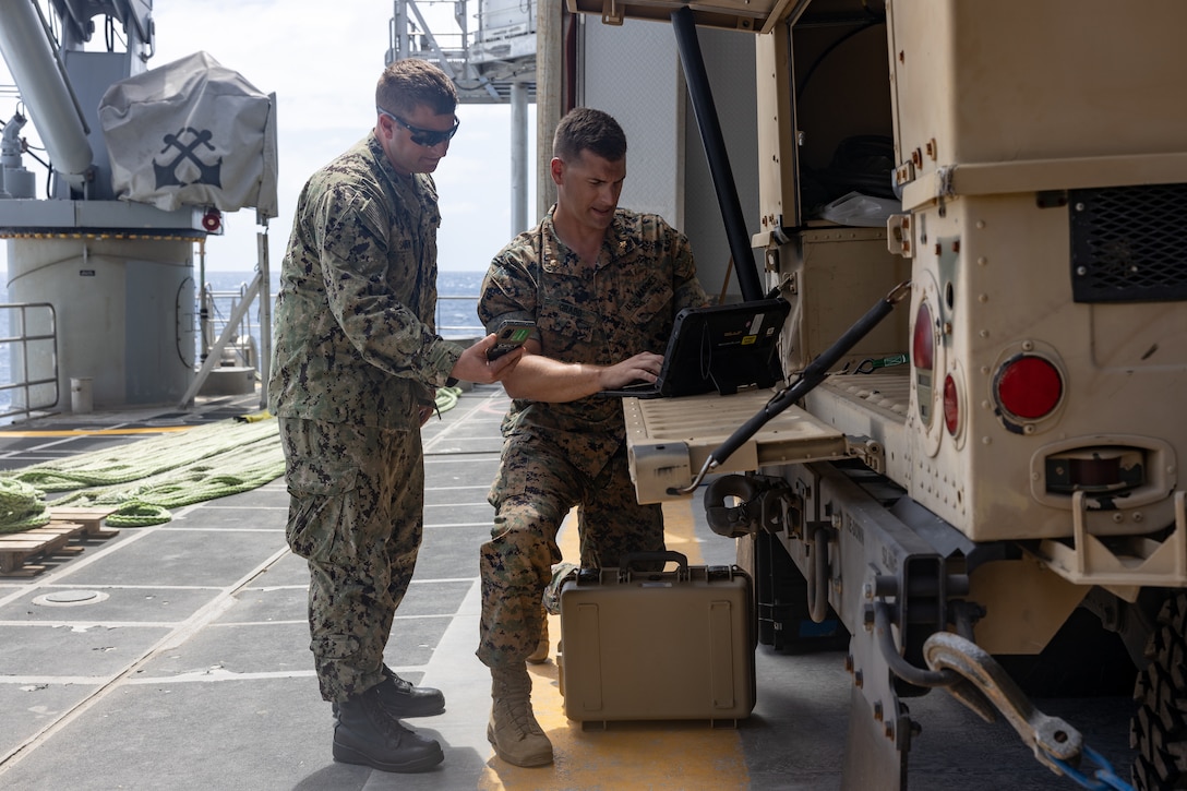 Marine Corps Maj. Brooks Grado, an intelligence officer with U.S. Marine Corps Forces, Southern Command and Navy Cmdr. Jonathan Saburn, a future operations officer assigned to U.S. 4th Fleet, discuss future operating concepts aboard the expeditionary fast transport vessel USNS Burlington (T-EPF-10) during a fleet experimentation period. The fleet experimentation serves to demonstrate Navy/Marine Corps integration by testing concepts that would be employed during expeditionary advance base operations, evaluating expeditionary systems for force protection and coordinated electronic warfare.