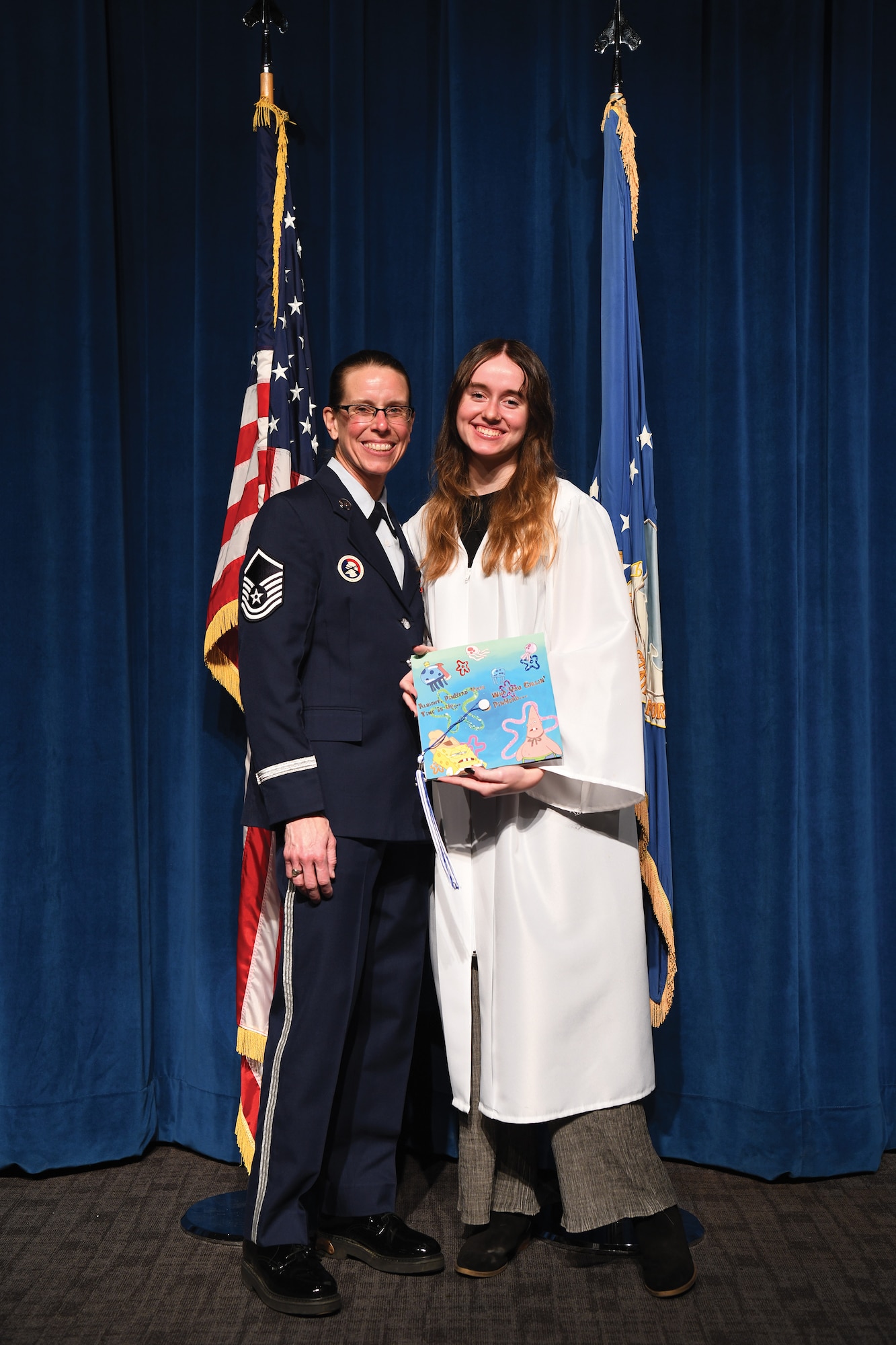 High school senior, Taylor Godsey, joins her mother, Master Sgt. Jennifer Godsey, 445th Force Support Squadron services supervisor, during the 445th Airlift Wing’s 2021 Annual Awards event, April 2, 2022 at Wright-Patterson Air Force Base, Ohio. Godsey received a special surprise, April 1, 2022 when Miami East High School in Casstown, Ohio held an early graduation ceremony for Taylor because the sergeant would miss the graduation due to a deployment.