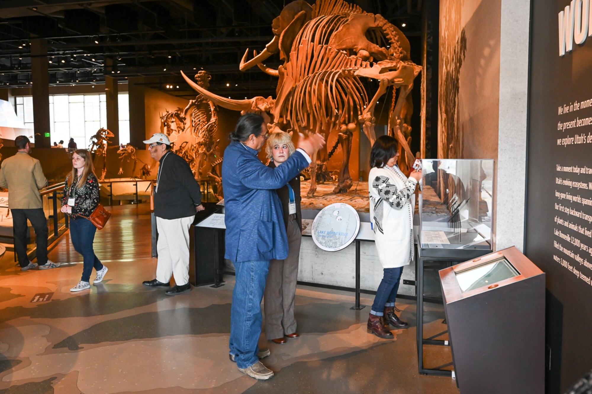 Tribal and military representatives view a permanent Paleoindian exhibit featuring artifacts.