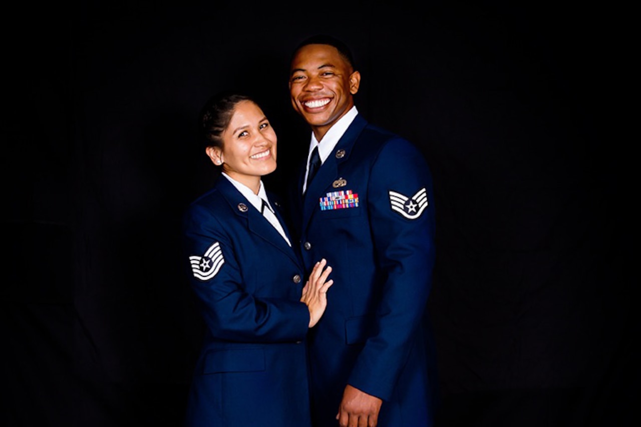 An Air Force couple in uniform smiles for a photo.