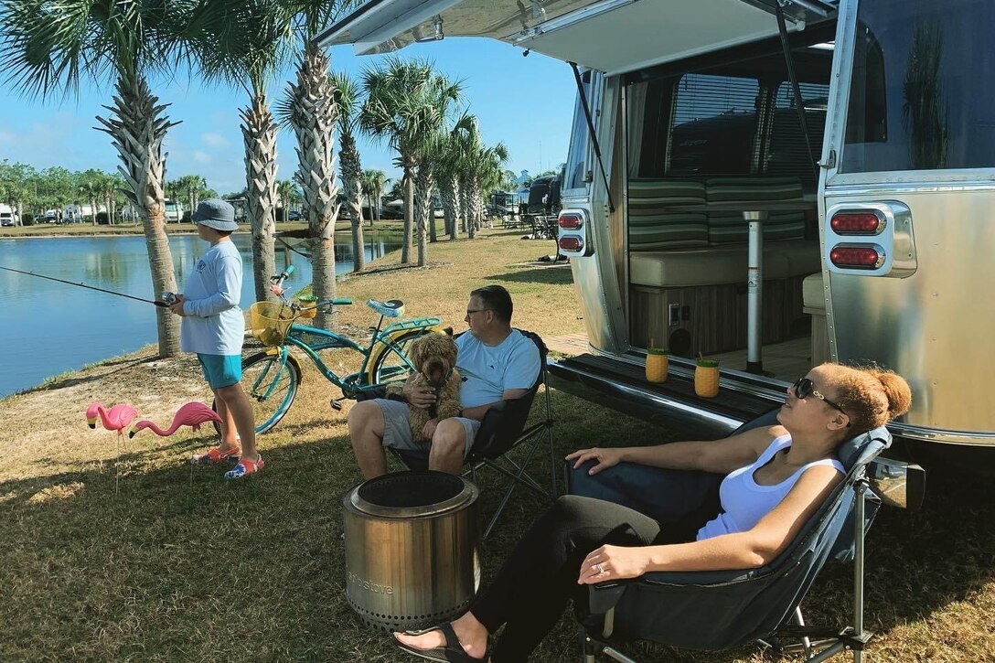 A family lounges and fishes near a body of water.