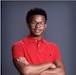 Young man poses with his arms crossed over his chest.