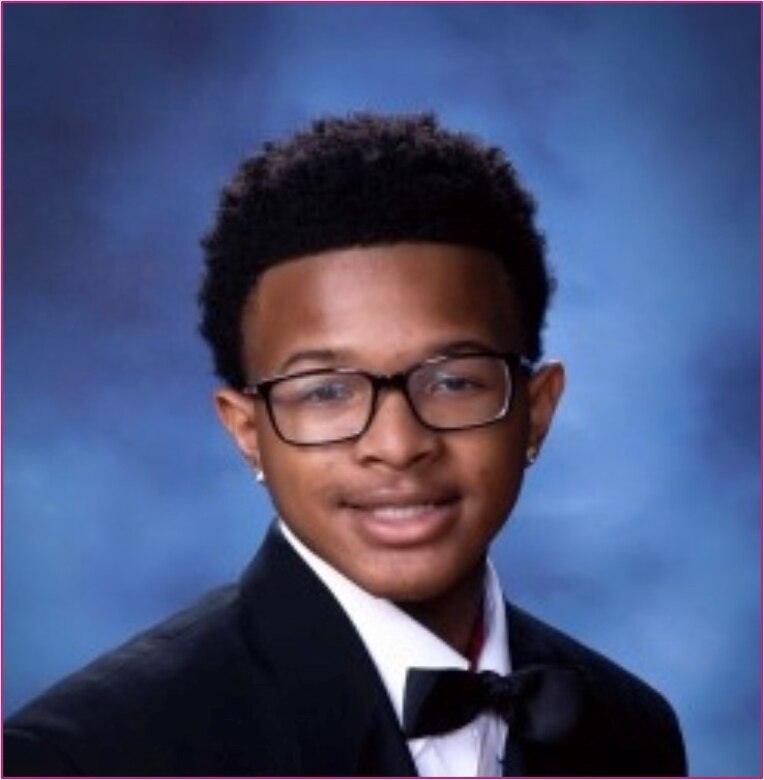 A young man poses in jacket and bow tie.