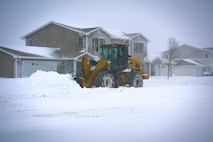 A snow plow is clearing the streets of snow on Minot Air Force Base, North Dakota, April 6. 2022. The Pavements and heavy Equipment shop of 5th Civil Engineer Squadron assisted in clearing the roads during a blizzard. (U.S. Air Force photo by Airman Alysa Knott)