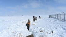 Airmen are shoveling snow April 26, 2022 on Minot Air Force Base, North Dakota. They are digging a trench to make sure the launch facility isn’t flooded by the melting snow. (U.S. Air Force photo by Senior Airman Caleb Kimmell)