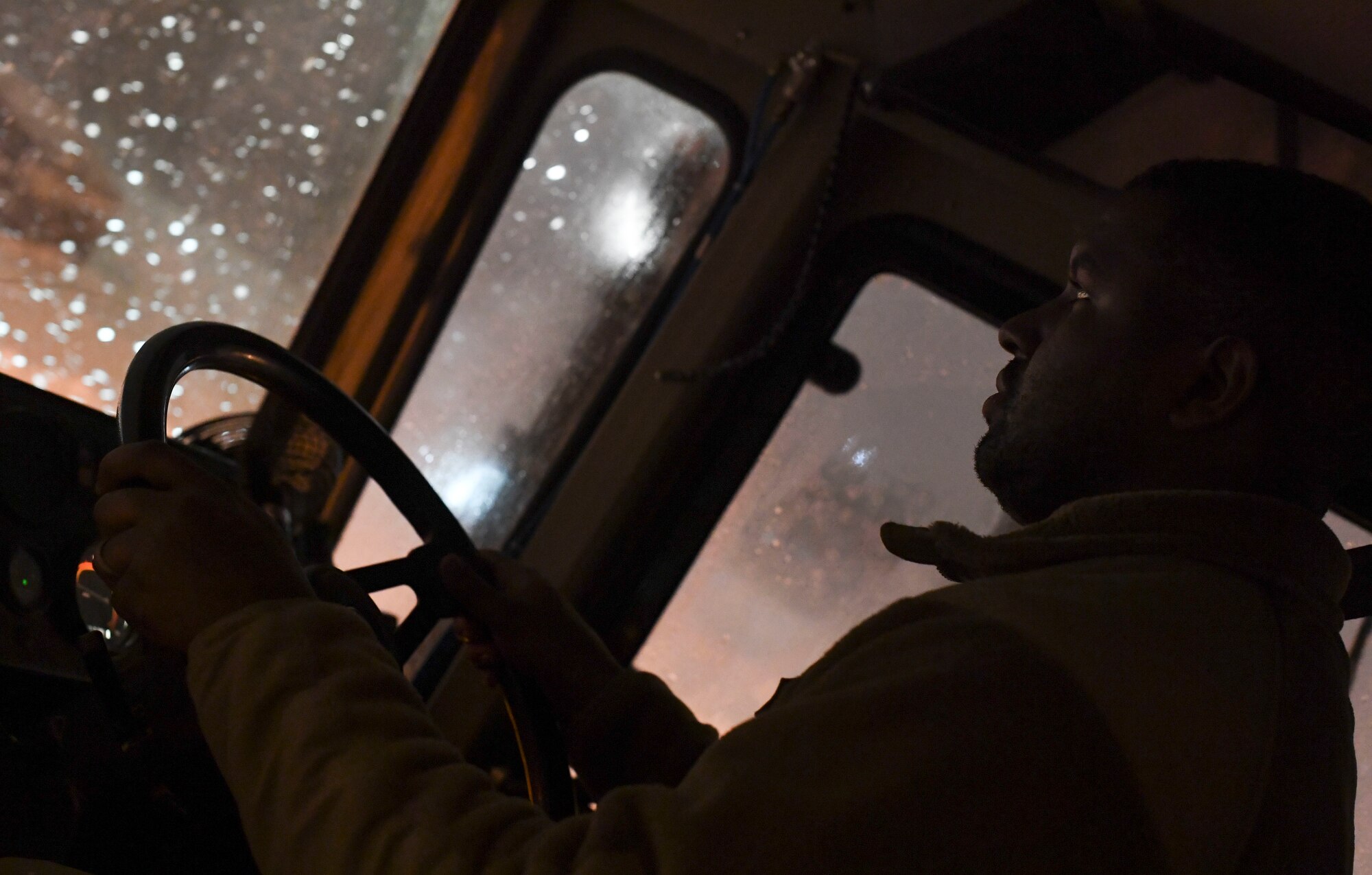 A snow plow drives on the flight line