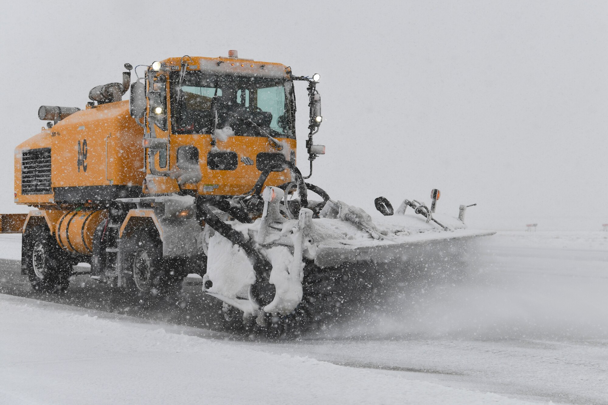 A snow broom drives on the flight line