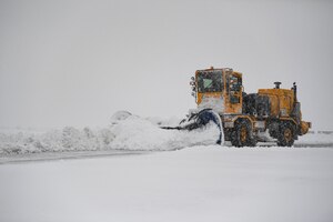 A plow drives on the flight line