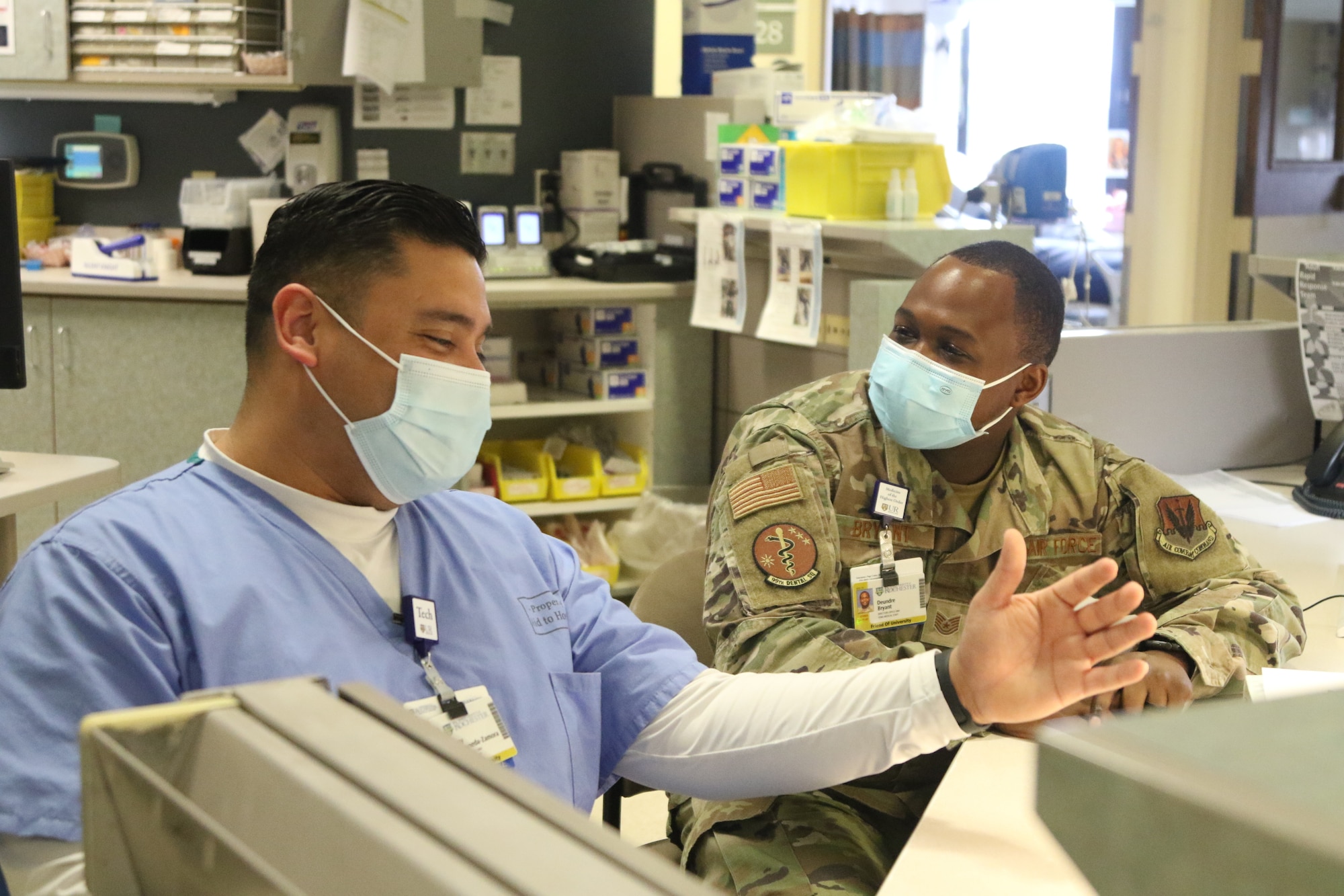 U.S. Air Force Tech Sgt. Deundre Bryant, right, a  medical administrator, checks up on Tech Sgt. Rony Castaneda-Zamora a medical technician, while supporting the COVID response operations at University of Rochester Medical Center, Rochester, New York, Feb.16, 2022.