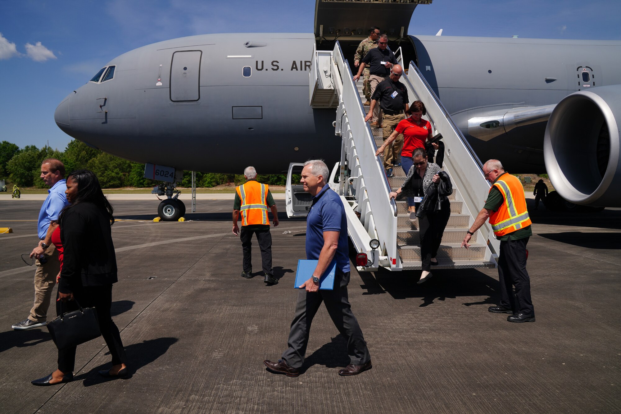 Civic leaders walk down the stairs of a KC-46A Pegasus aircraft at Duke Field flight line