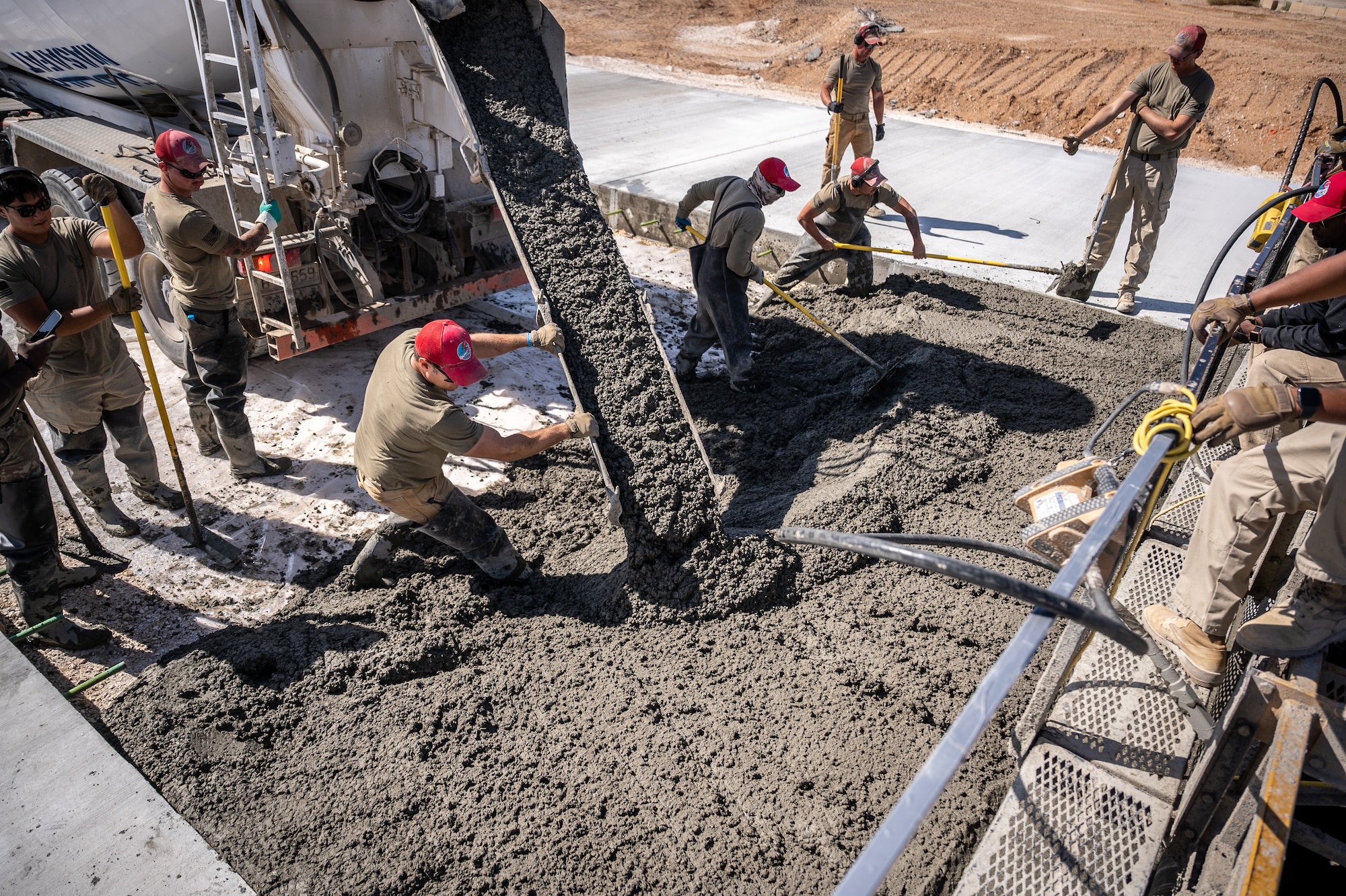 1st Expeditionary Civil Engineer Group Airmen pour more than 12,000 cubic meters of concrete for a runway overrun repair project at an undisclosed location in Southwest Asia, April 14, 2022. (U.S. Air Force photo by Master Sgt. Christopher Parr)