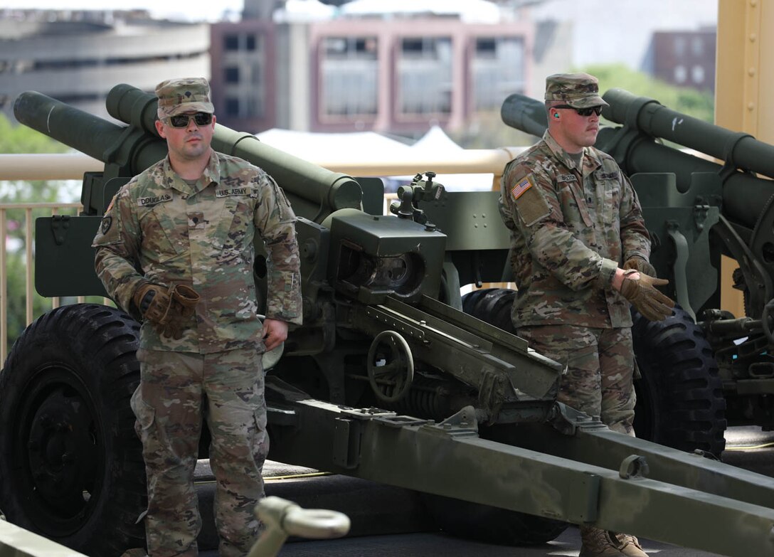 Two Soldiers from the 2/138th Field Artillery Bn. wait for the command to load thir 105mm howitzer on the Second Street Bridge on April 23, 2022, in Louisville, Ky. The Soldiers manned six – 105mm howitzers in support of Kentucky's Thunder over Louisville. (U.S. Army photo by Staff Sgt. Ryan Wilhoit)