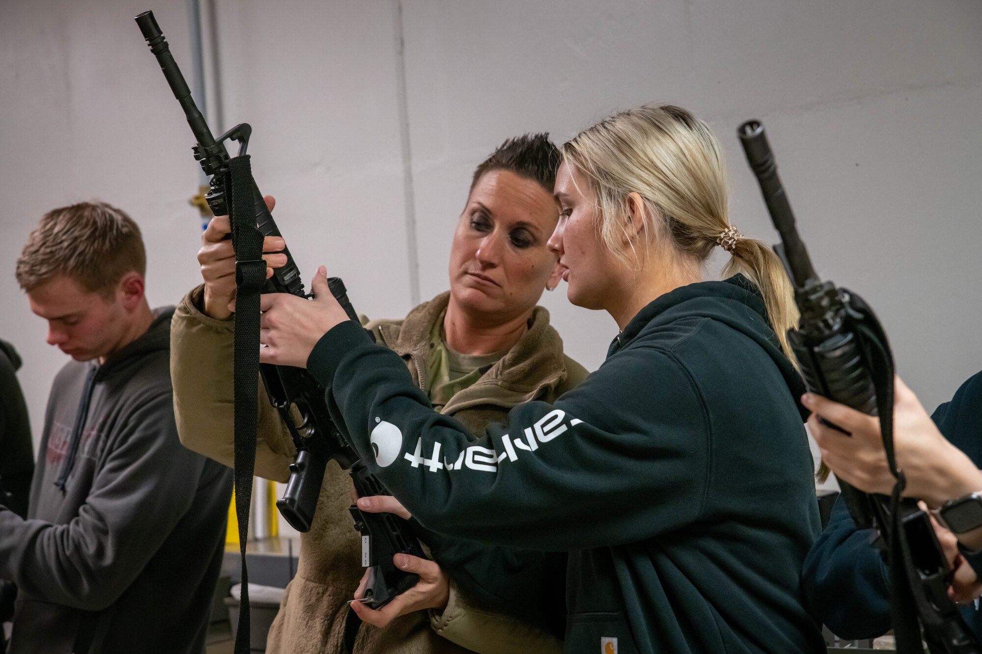 South Dakota Air National Guard Master Sgt. Mandy Jongeward, left, security forces flight sergeant, 114th Fighter Wing, identifies parts of the M4 carbine for student flight member Ellie Anderson, right, during a weapons familiarization training at Joe Foss Field, April 30, 2022.