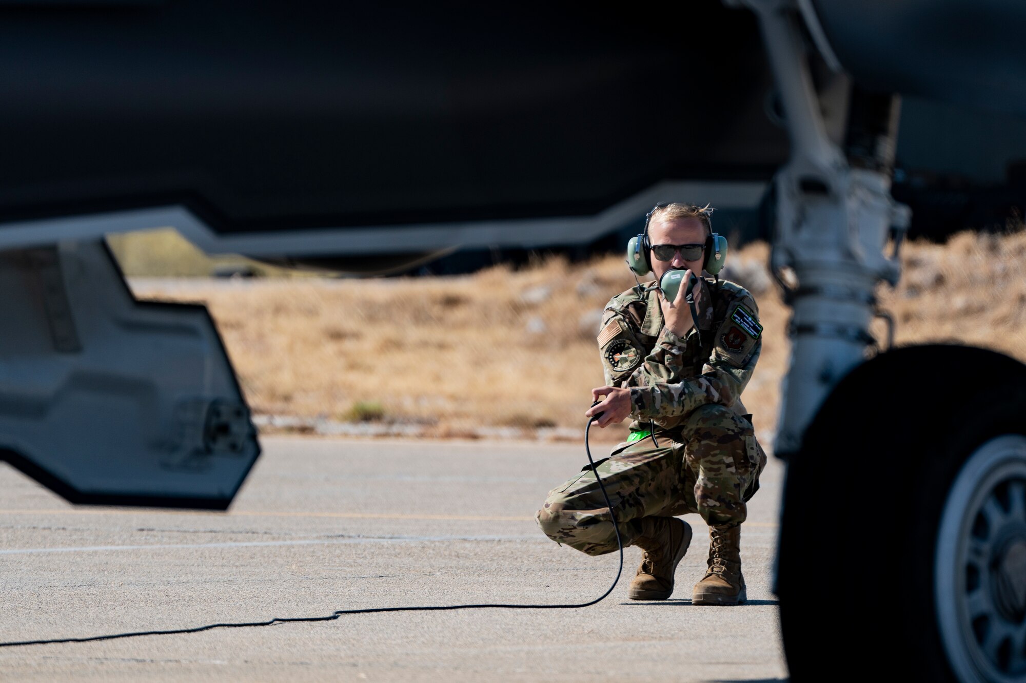 Photo of an Airman speaking into a protective headset