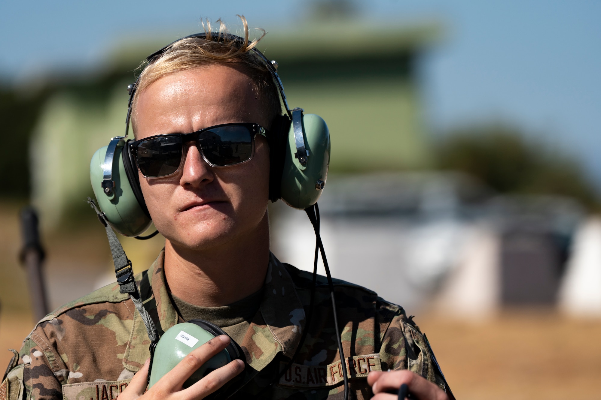 Photo of an Airman wearing a protective headset and sunglasses