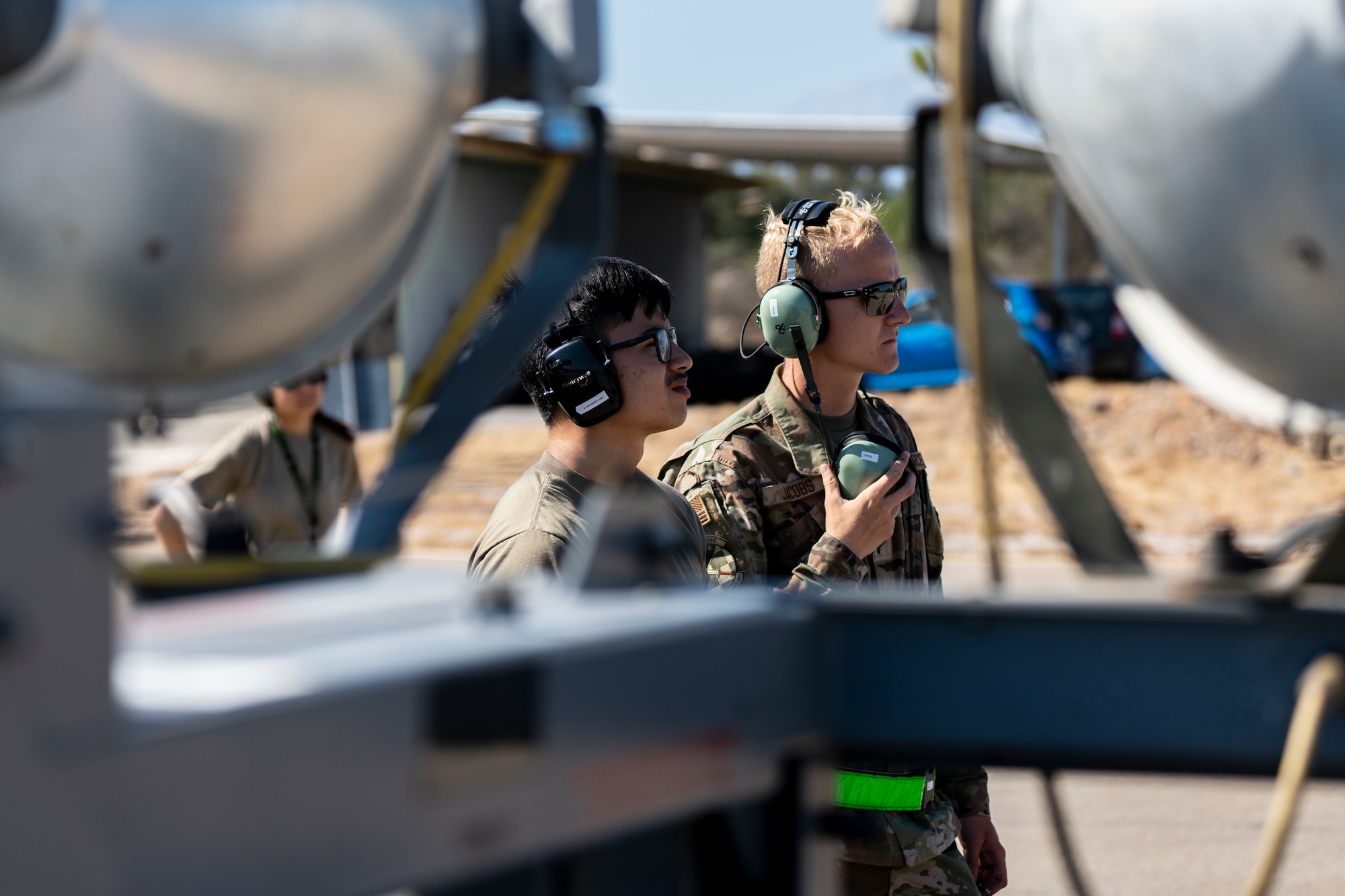 A photo of two Airmen standing behind lighting equipment