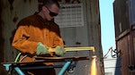 Man cuts metal with a torch