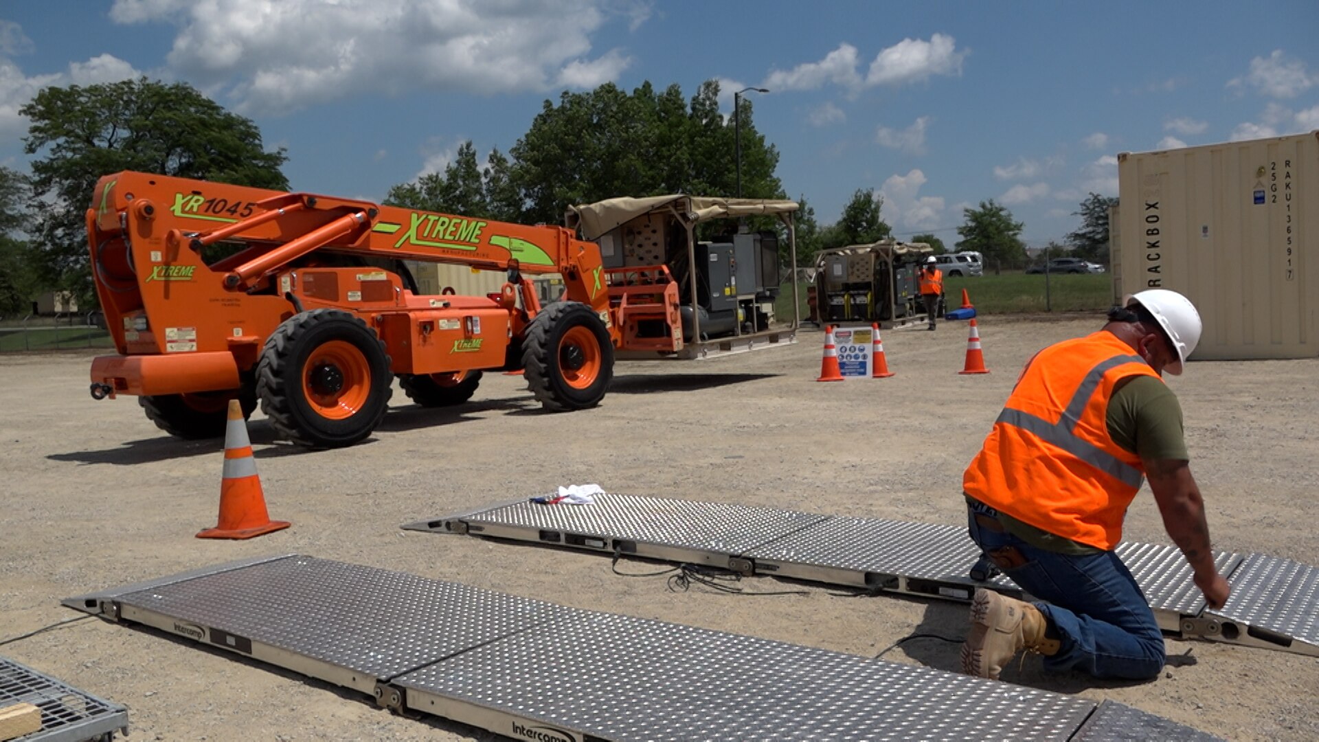 Man working on panel with machinery in background