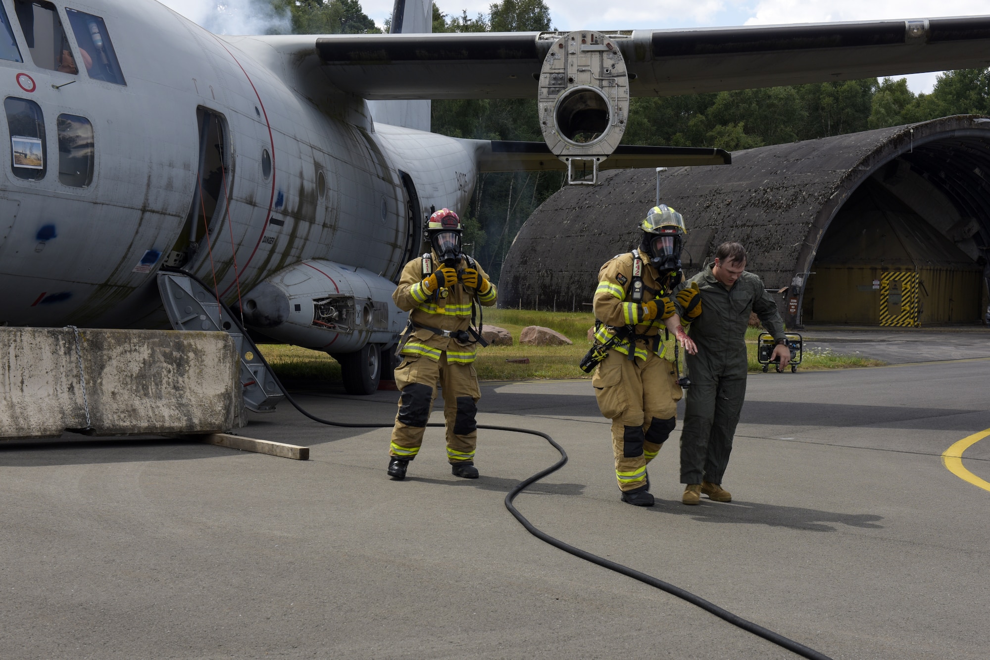Firefighters remove a simulated casualty from an aircraft
