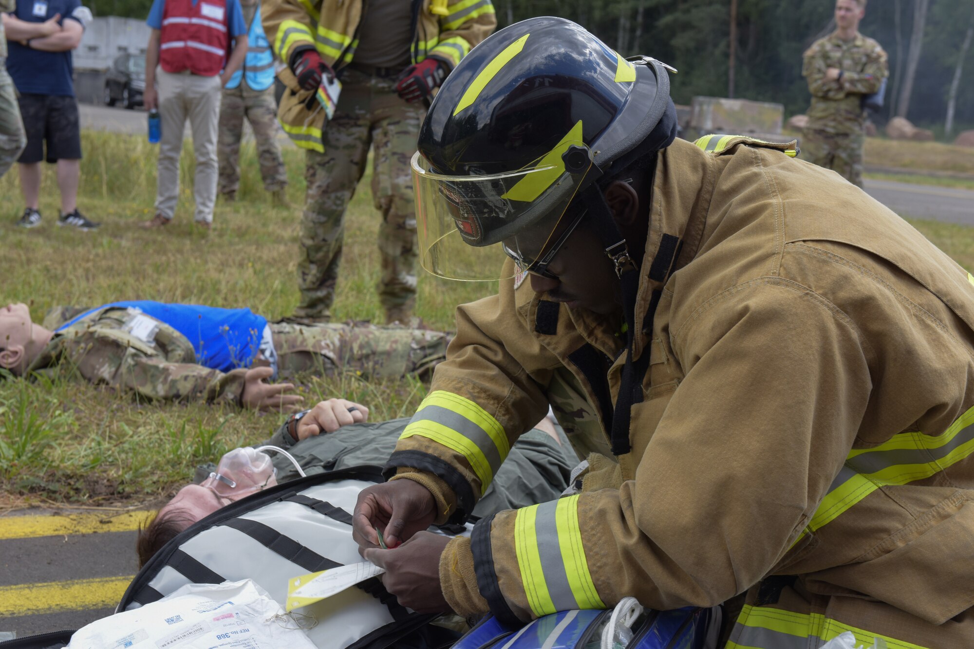 Airman provides first aid for a simulated aircraft crash
