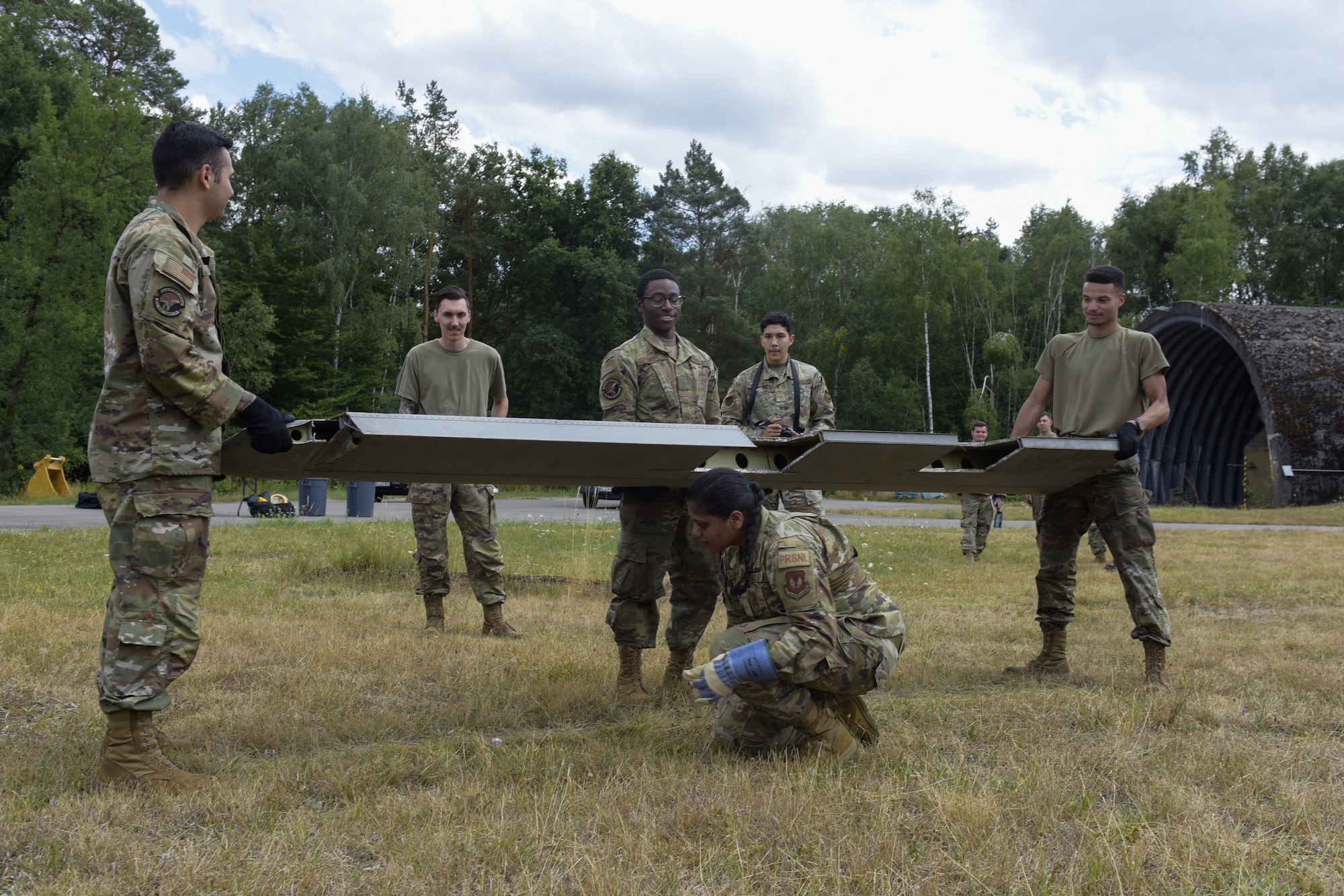 Airmen lift debris from simulated aircraft crash