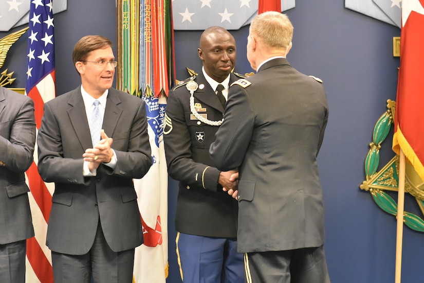 Soldiers in dress uniform shaking hands.