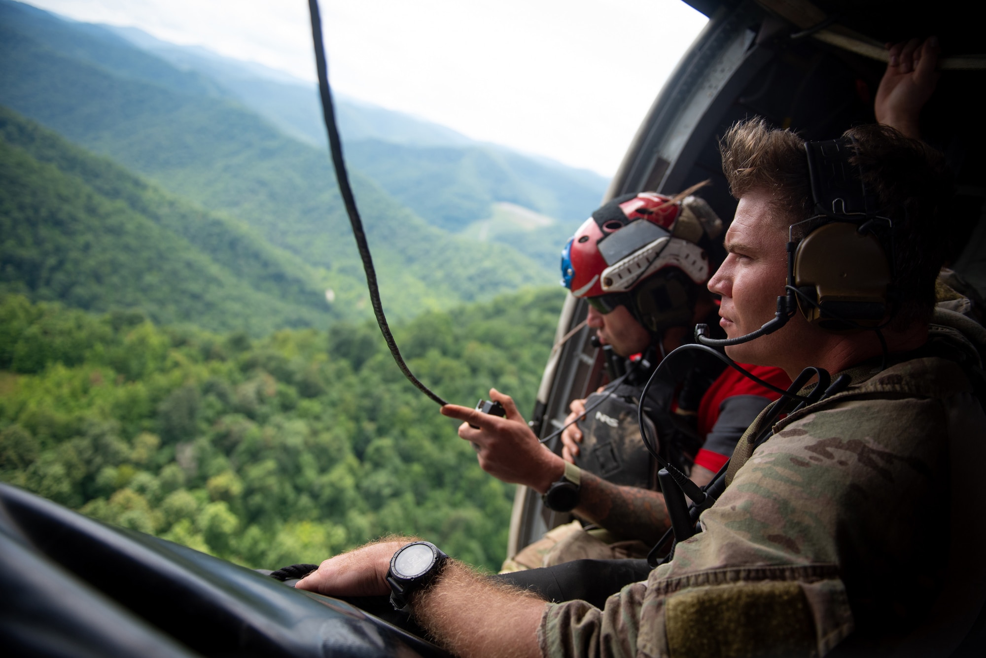 An Airman from the Kentucky Air National Guard’s 123rd Special Tactics Squadron search for flood victims from a helicopter in Eastern Kentucky on July 30, 2022. In response to devastating flooding, the unit coordinated 29 rotary-wing relief missions, rescued 19 people and two dogs, and recovered four bodies. Their command-and-control efforts also facilitated the assistance or recovery of 40 people. (U.S. Air National Guard photo by Staff Sgt. Clayton Wear)