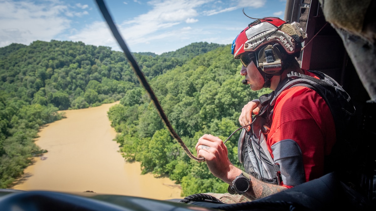 An Airman from the Kentucky Air National Guard’s 123rd Special Tactics Squadron search for flood victims from a helicopter in Eastern Kentucky on July 30, 2022. In response to devastating flooding, the unit coordinated 29 rotary-wing relief missions, rescued 19 people and two dogs, and recovered four bodies. Their command-and-control efforts also facilitated the assistance or recovery of 40 people. (U.S. Air National Guard photo by Staff Sgt. Clayton Wear)