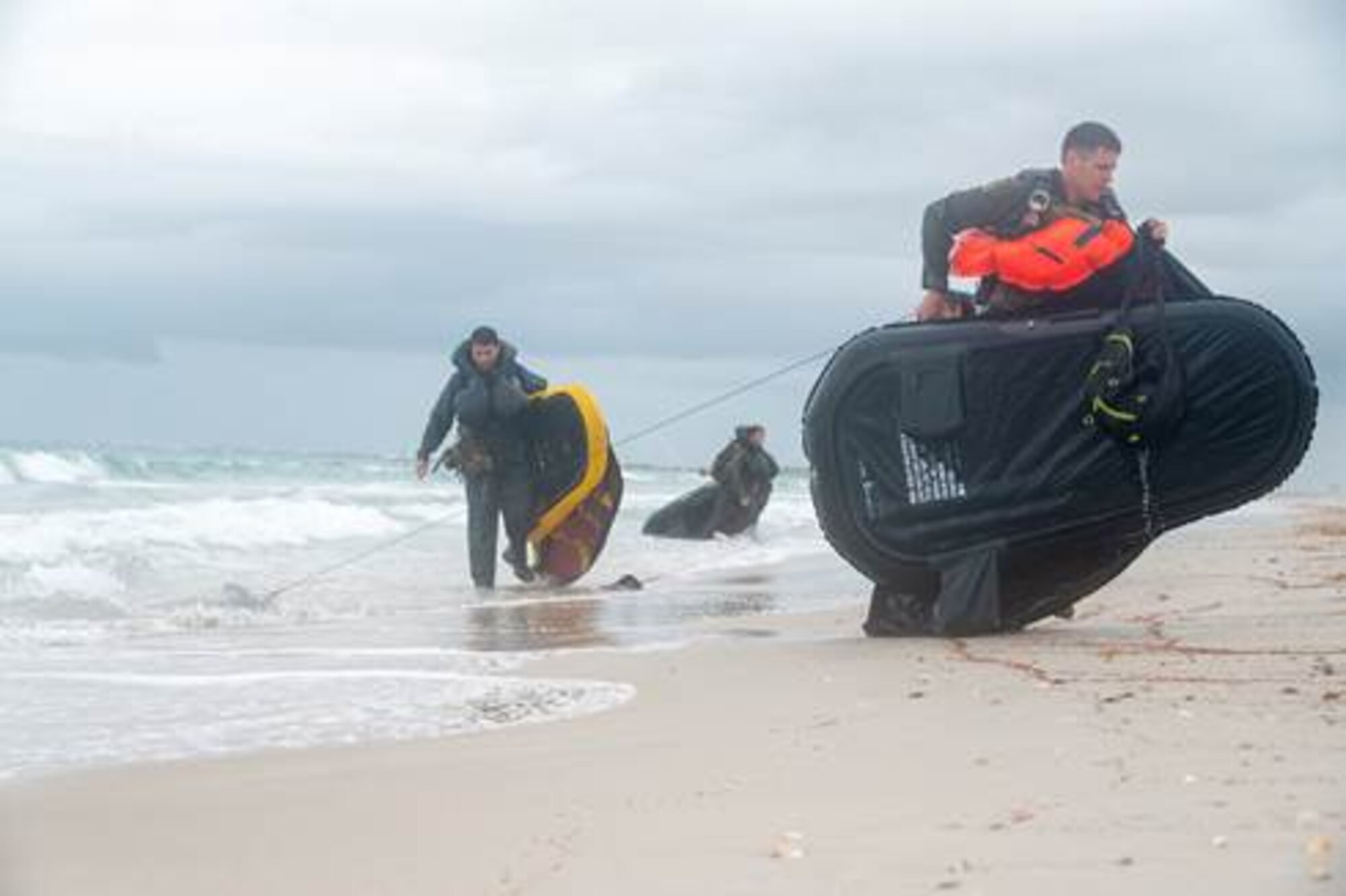 Airmen drag inflatable rafts ashore