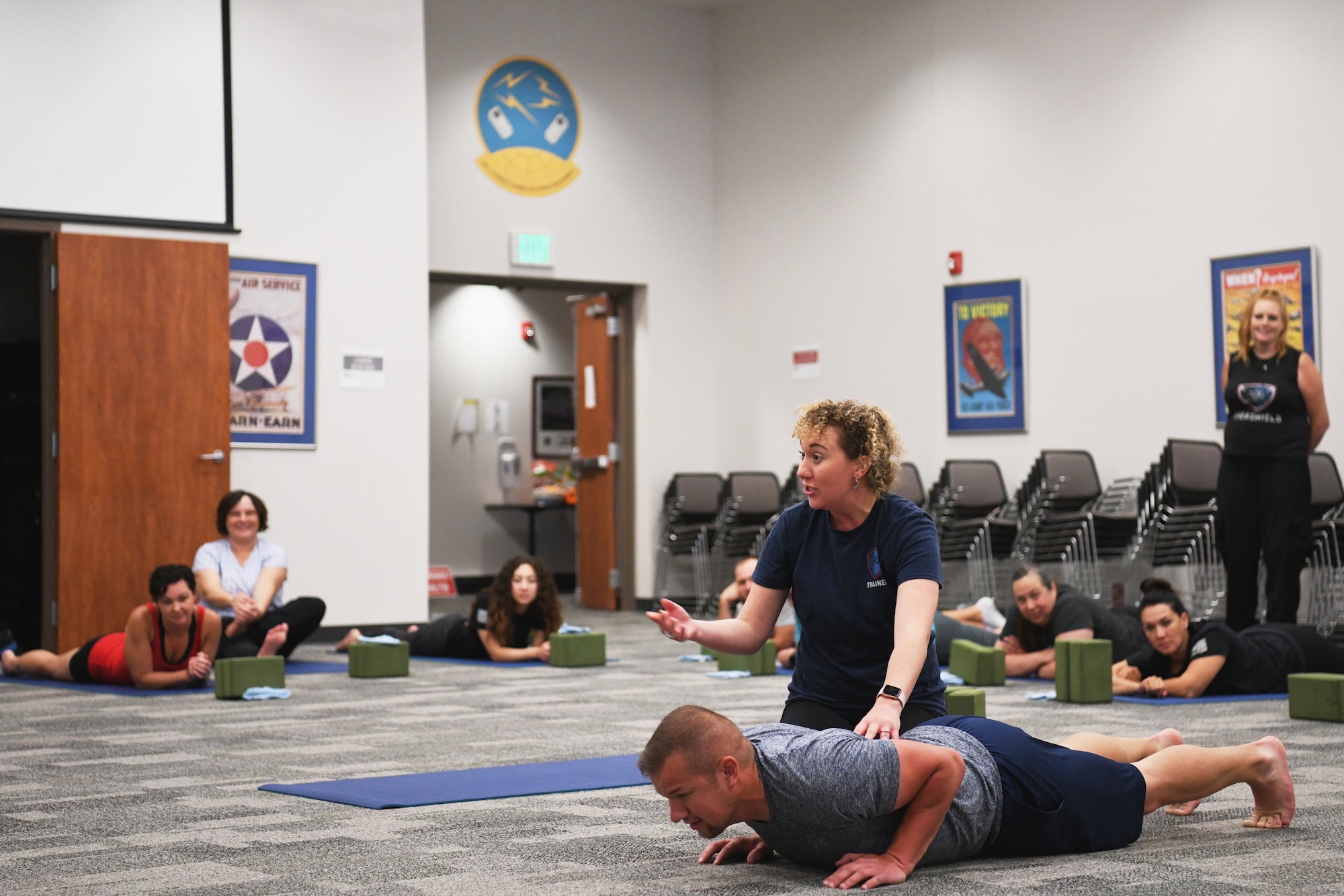 Olivia Mead, a yoga instructor, teaches a yoga class July 18, 2022 at the 178th Wing in Springfield, Ohio. The training is a part of a pilot program called Yoga Shield, which aims to teach Airmen to reduce stress and to build mental and physical resiliency through yoga. (U.S. Air National Guard photo by Shane Hughes)