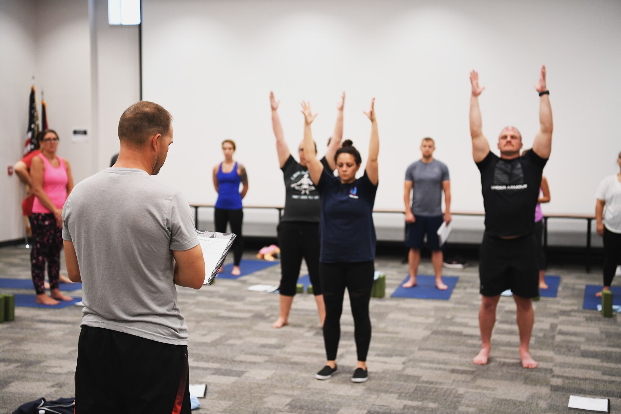 An Airman practices leading a yoga class July 18, 2022 at the 178th Wing in Springfield, Ohio. The training is a part of a pilot program called Yoga Shield, which aims to teach Airmen to reduce stress and to build mental and physical resiliency through yoga. (U.S. Air National Guard photo by Shane Hughes)