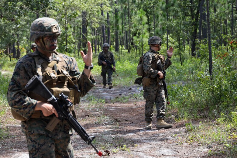 U.S. Marines with 8th Engineer Support Battalion, Combat Logistics Regiment 27, patrol down a road during Summer Pioneer 2022 on Camp Lejeune, North Carolina, July 20, 2022. Summer Pioneer 2022 is a naval engineering exercise demonstrating integrated U.S. Marine Corps and U.S. Navy formations to establish and sustain Expeditionary Advanced Bases and Maritime Domain Awareness. (U.S. Marine Corps photo by Lance Cpl. Jessica J. Mazzamuto)