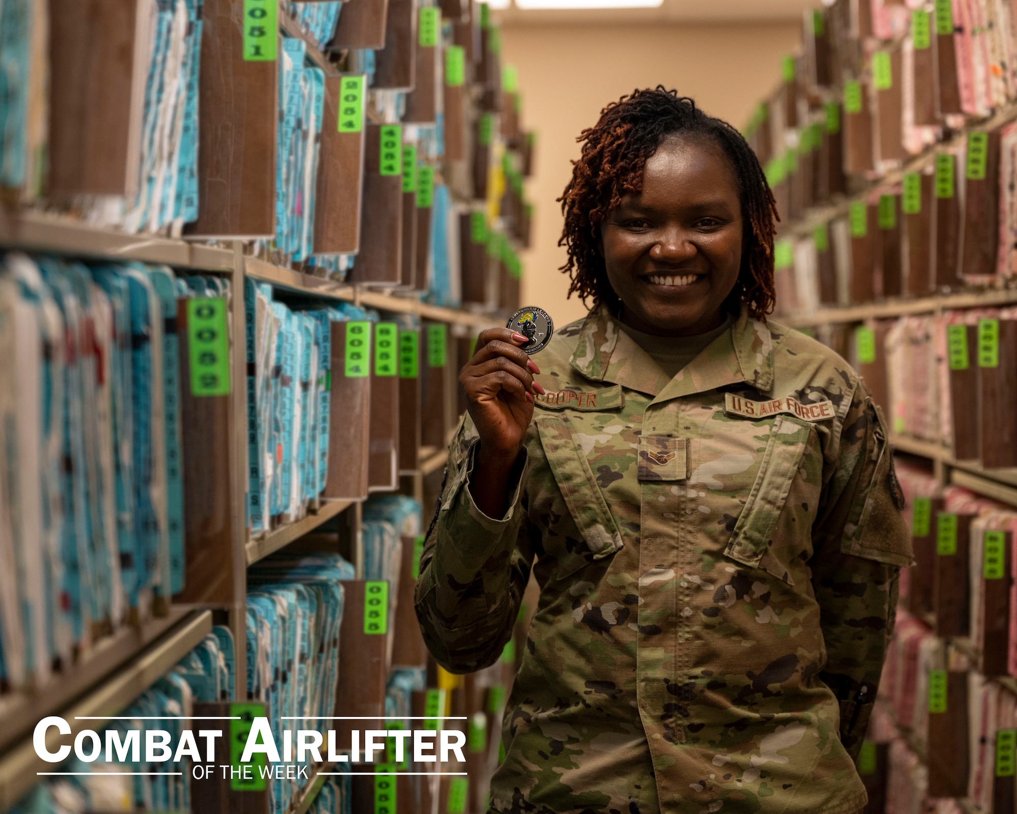 A woman in uniform poses for a photo in front of a row of files.