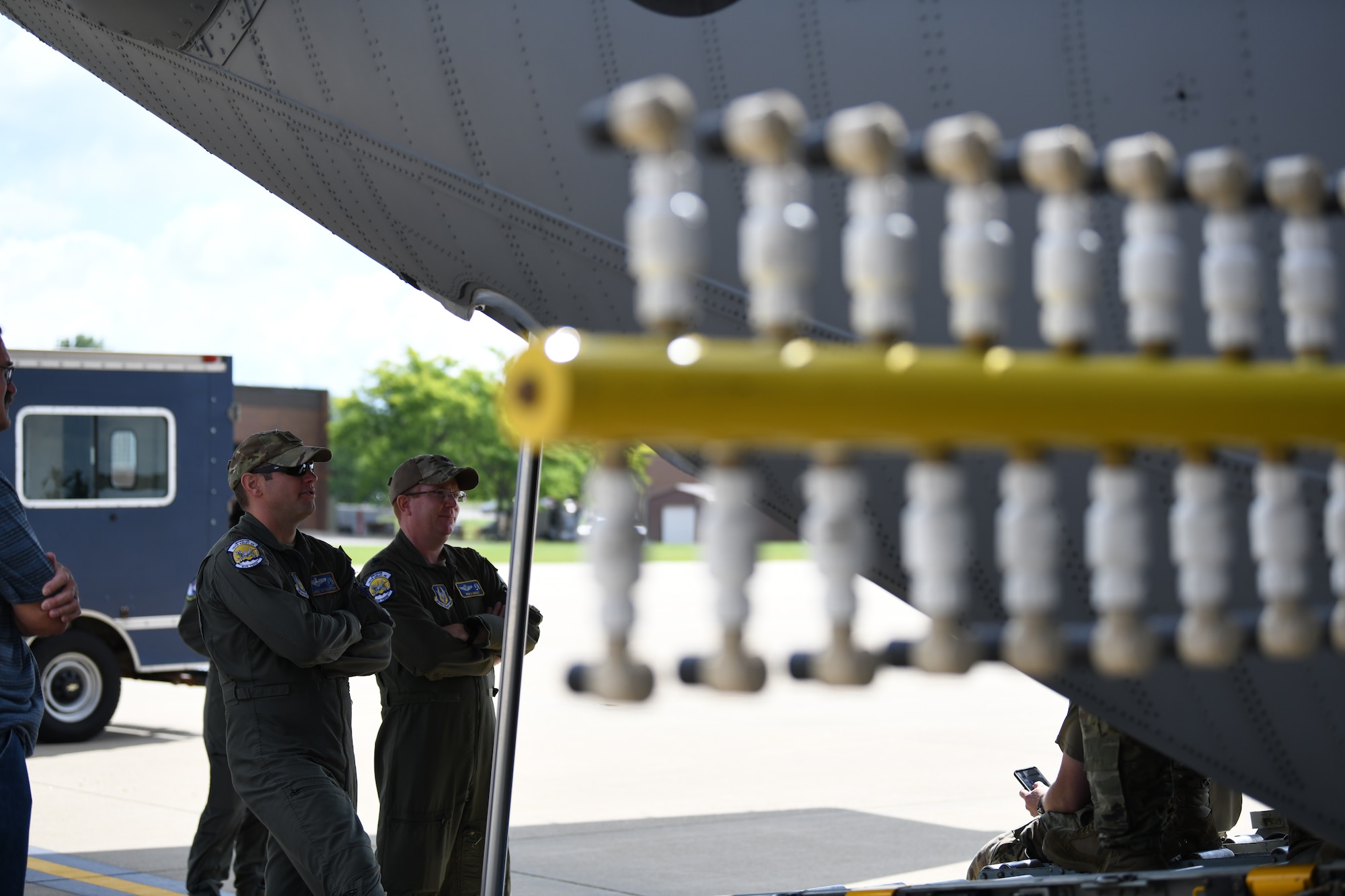 Maj. Luke Stouffer and Maj. Ryan Cooley, both aircrew members assigned to the 757th Airlift Squadron, watch preparations before flying a C-130H Hercules aircraft and installed prototype modular aerial spray system for its first test flight at Youngstown Air Reserve Station, Ohio, July 25, 2022.