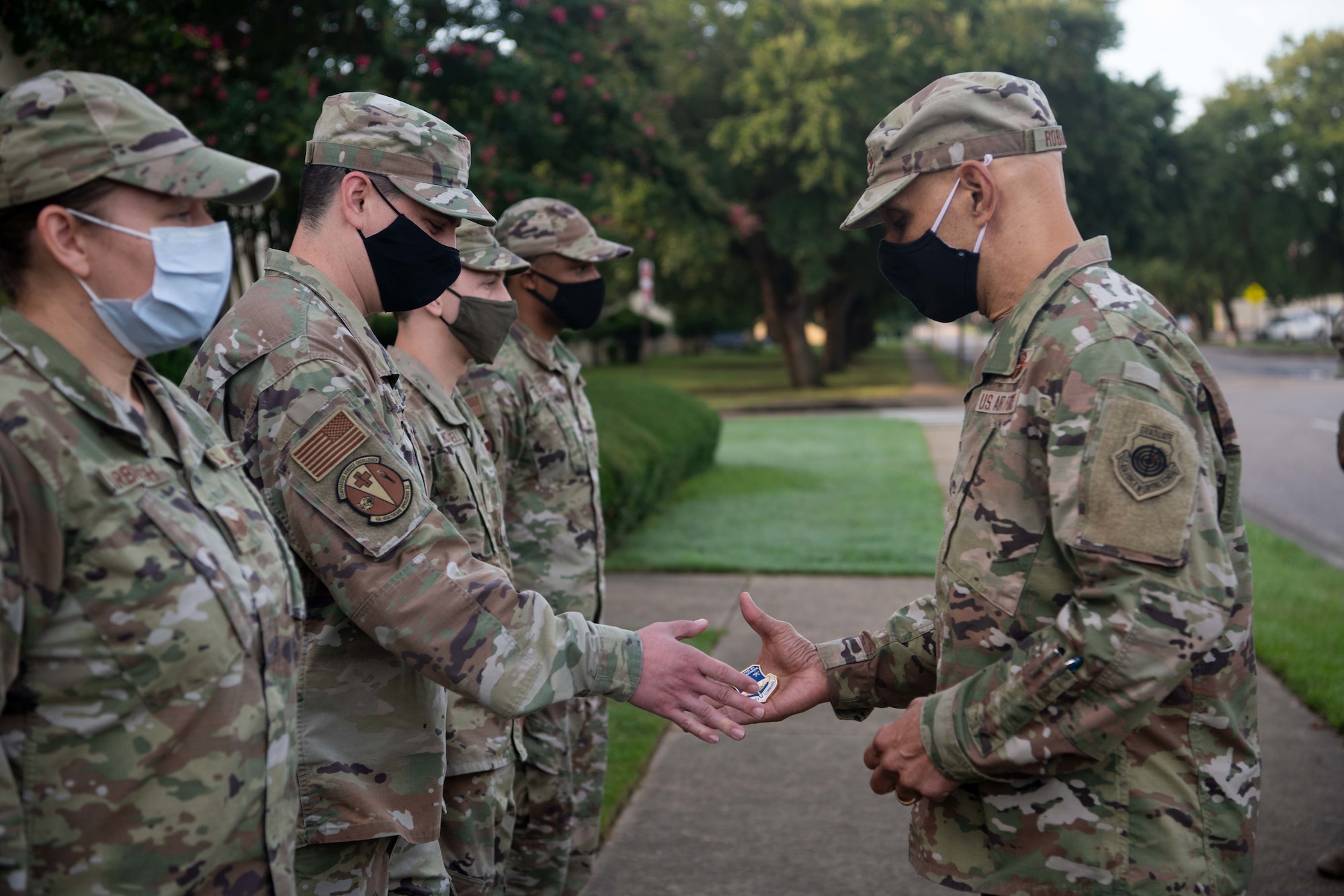 Lt. Gen. Brian Robinson, commander of Air Education and Training Command, presents coins to several 42nd Air Base Wing enlisted Airmen for their notable support to the wing, Air University and mission partners during a visit to Maxwell Air Force Base, Alabama, July 26, 2022. Robinson, his wife Maureen Robinson and Chief Master Sgt. Erik Thompson, command chief of AETC, met with several units and mission partners during their visit to Maxwell, July 25-26.