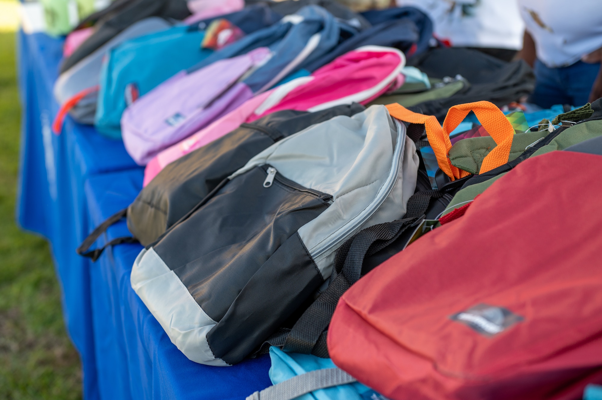 Backpacks sit at a table for a back to school event.