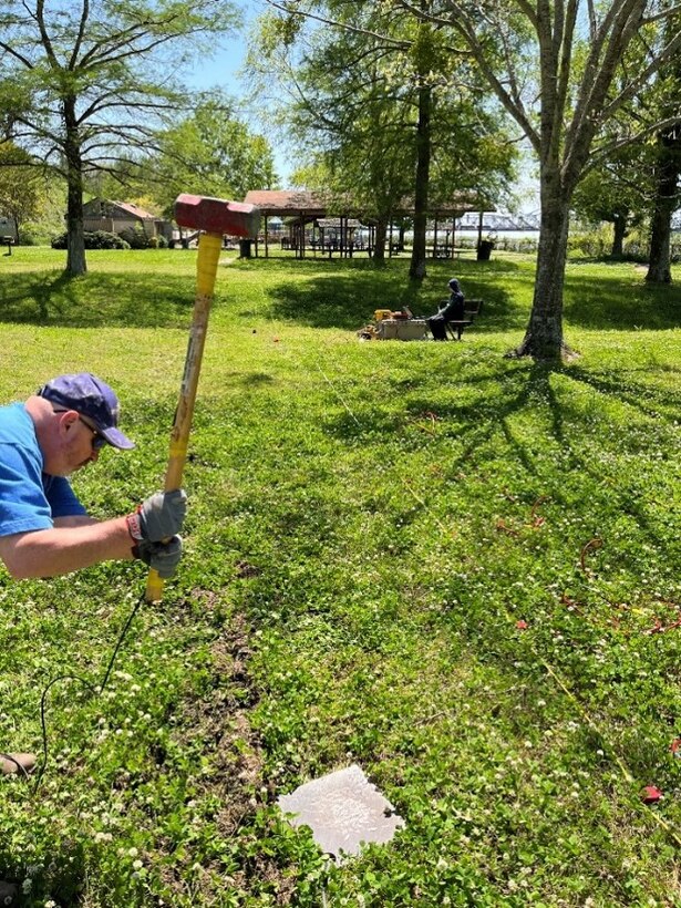 ERDC-GSL team member Kevin Taylor swings a sledgehammer to create an energy source for a Multichannel Analysis of Surface Waves survey