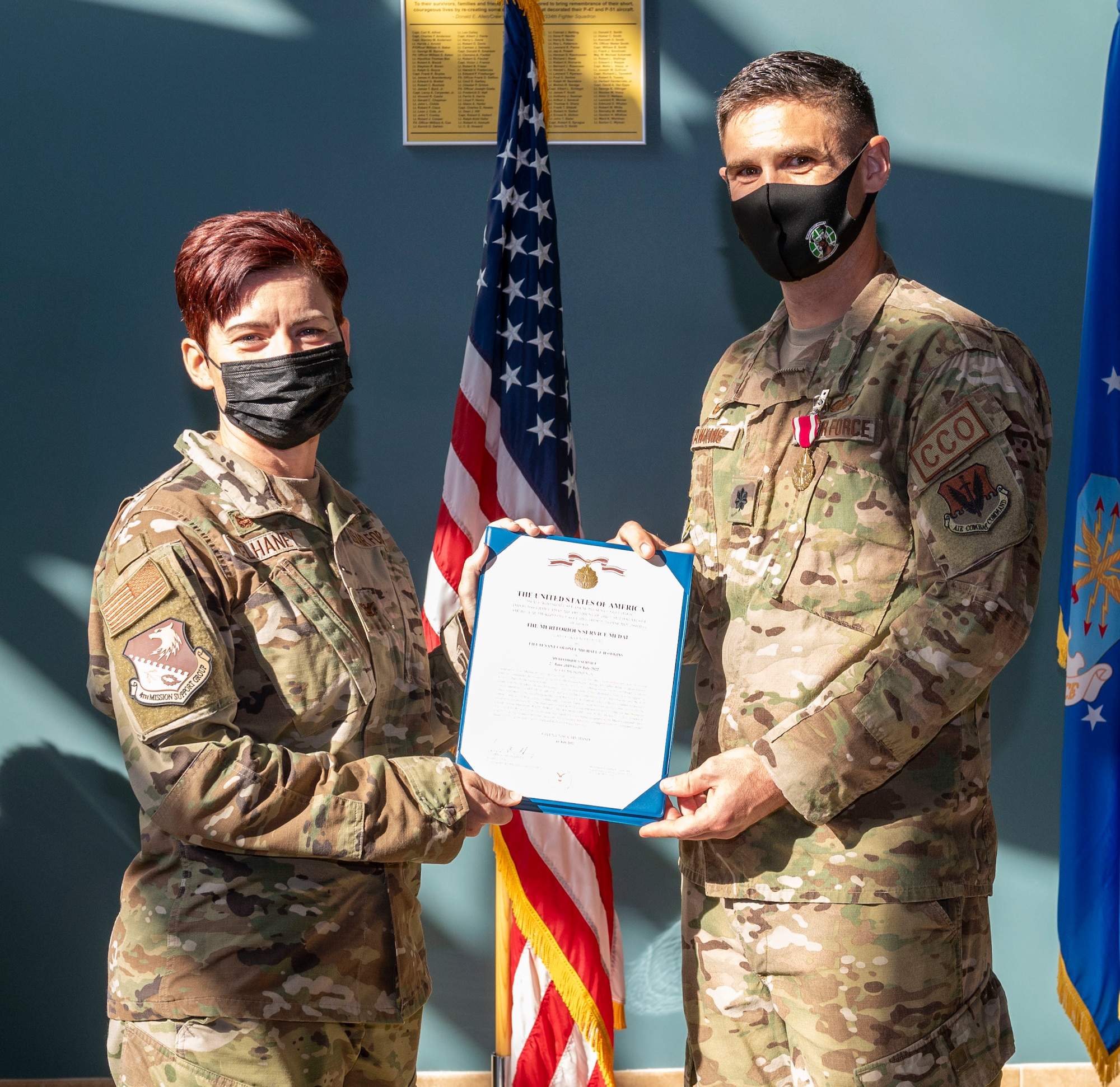 Col. Tammy McElhaney, left, 4th Mission Support Group commander, presents a Legion of Merit citation to Lt. Col. Michael Hawkins, outgoing 4th Contracting Squadron commander, during a change of command at Seymour Johnson Air Force Base, North Carolina, July 29, 2022. During his command, Hawkins provided contract support for over $3 billion in assets and ensured execution of an annual operations and maintenance budget of $90 million. (U.S. Air Force photo by Airman 1st Class Sabrina Fuller)