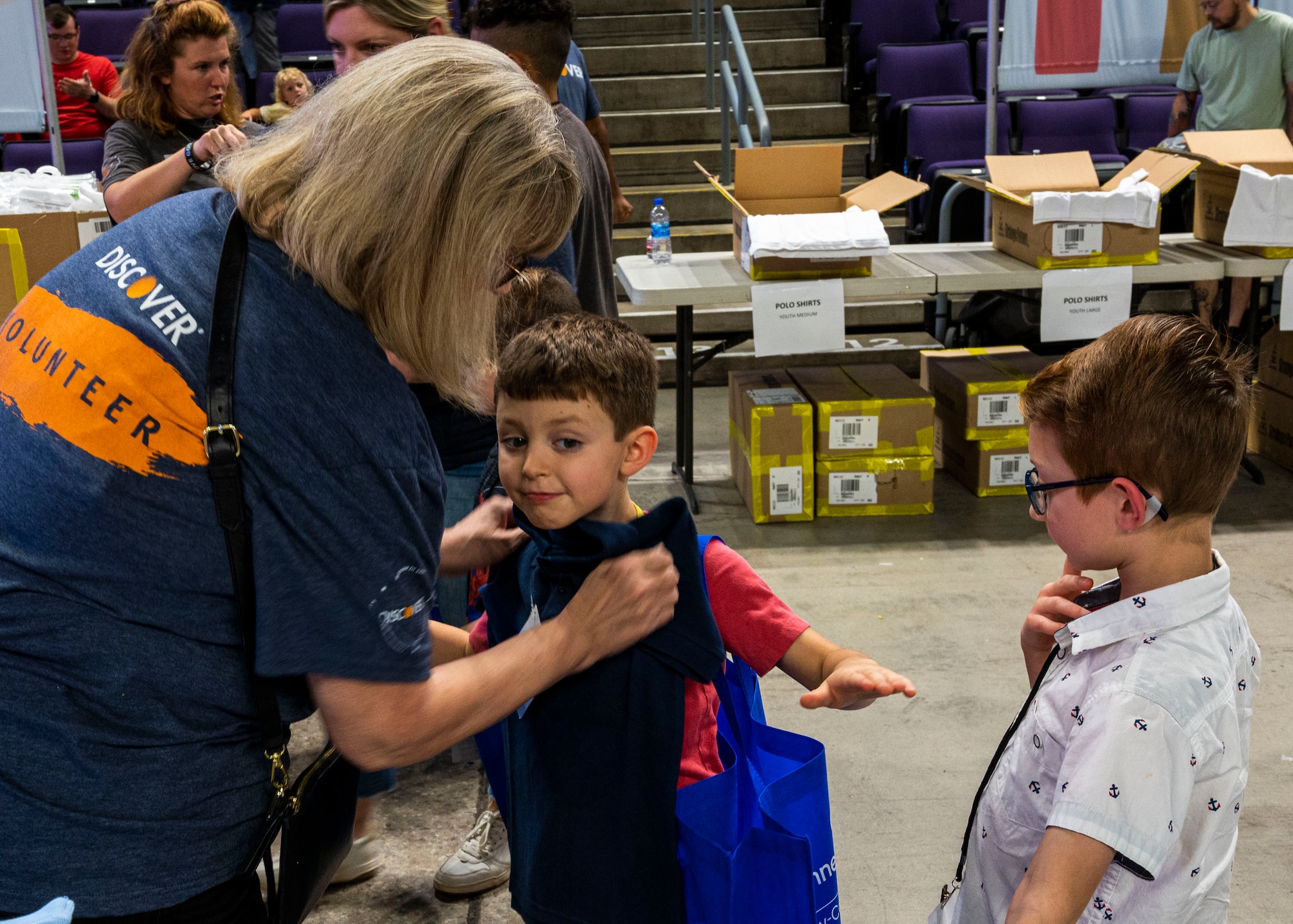 Two future students are fitted for new clothes by a volunteer at the Back to School Bash event July 20, 2022, at Grand Canyon University, Phoenix, Arizona.