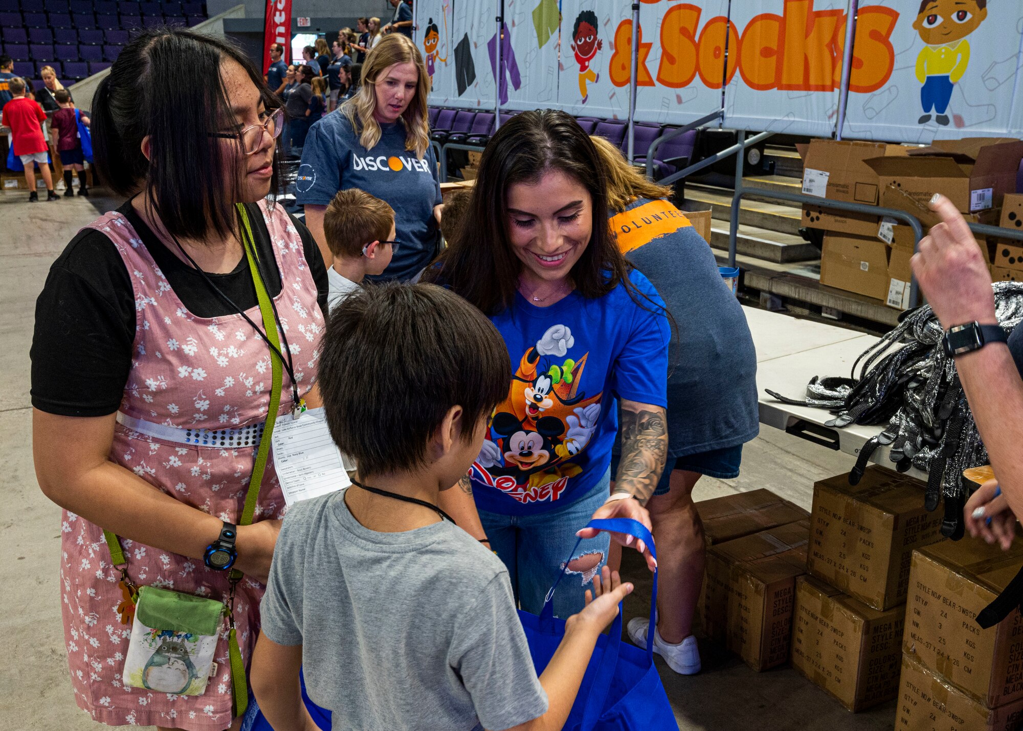 U.S. Air Force Staff Sgt. Angela Rudolph, 56th Force Support Squadron force management, helps a family shop for new school supplies and clothes at the Back to School Bash event July 20, 2022, at Grand Canyon University, Phoenix, Arizona.