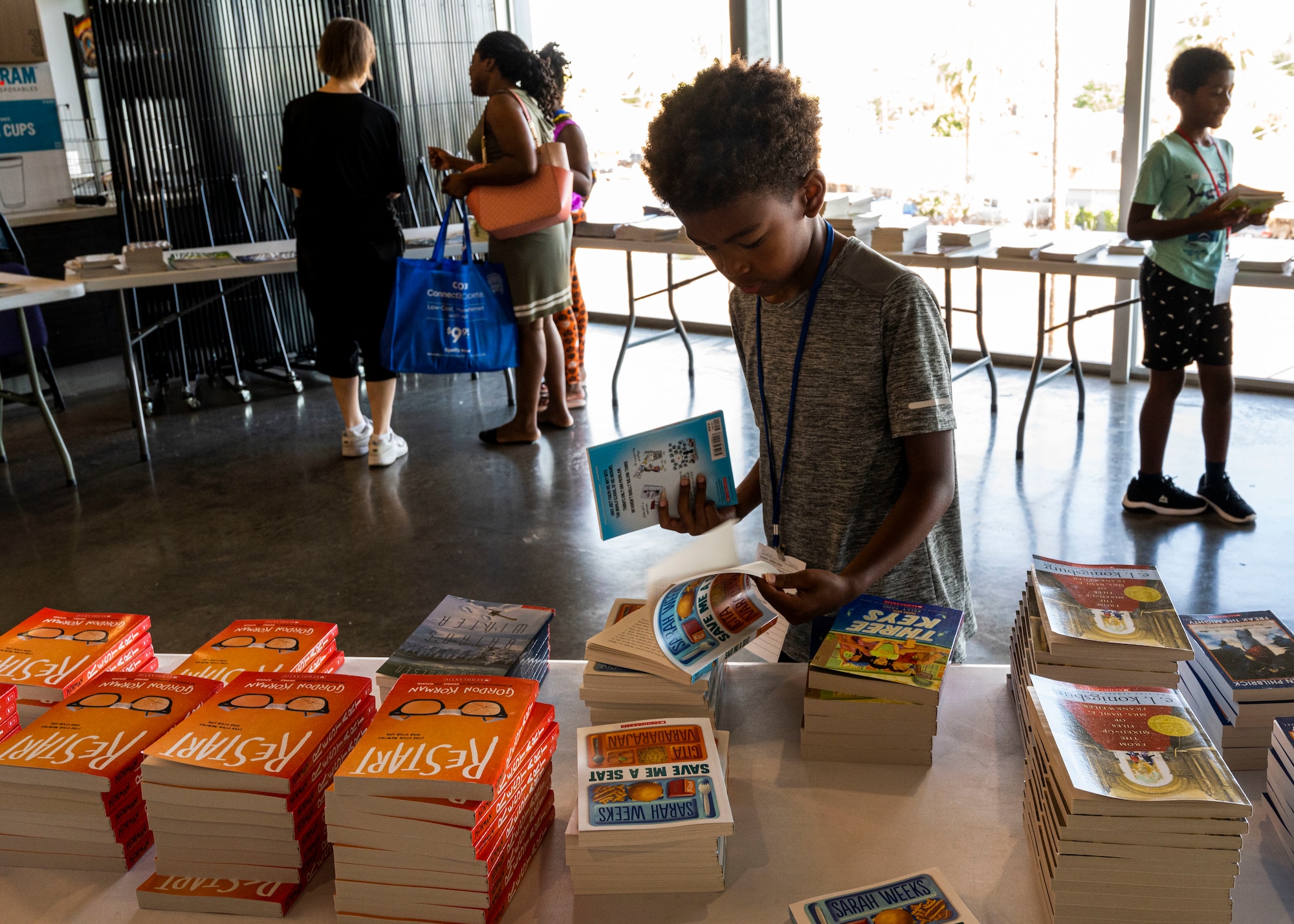 A child reads through some of the books available at the Back to School Bash event July 20, 2022, at Grand Canyon University, Phoenix, Arizona.