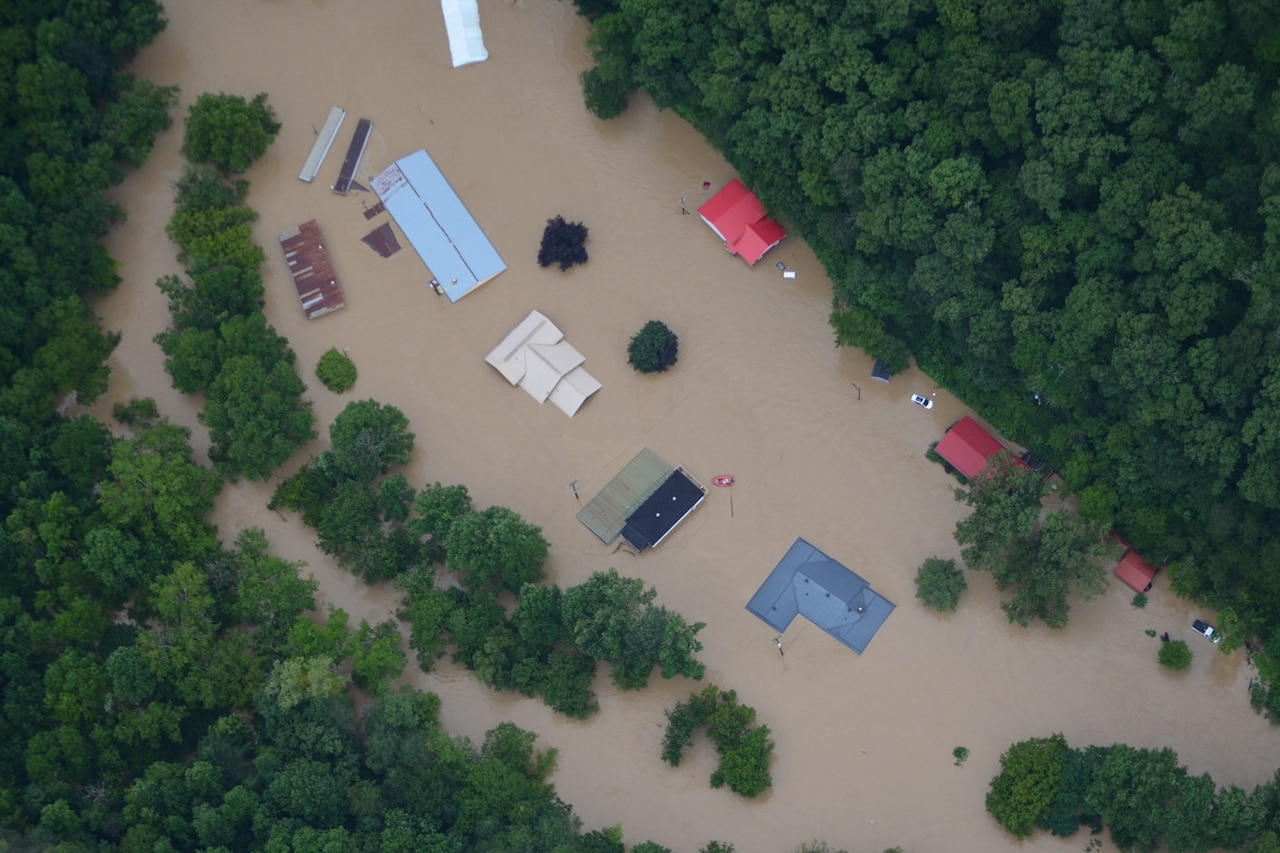 Overhead view of rooftops of homes submerged in floodwater.