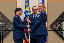 Lt. Col. Jennifer Harward, right, accepts command of the 341st Operational Medical Readiness Squadron from Col. Soo Sohn, 341st Medical Group commander, during a change of command ceremony July 28, 2022, at Malmstrom Air Force Base, Mont. Guidon bearer Master Sgt. Marshall Ritenour, 341st MDG first sergeant, looks on. The 341st OMRS consists of the dental, physical therapy, public health, mental health medical offices and optometry offices. (U.S. Air Force photo by Airman 1st Class Elijah Van Zandt)