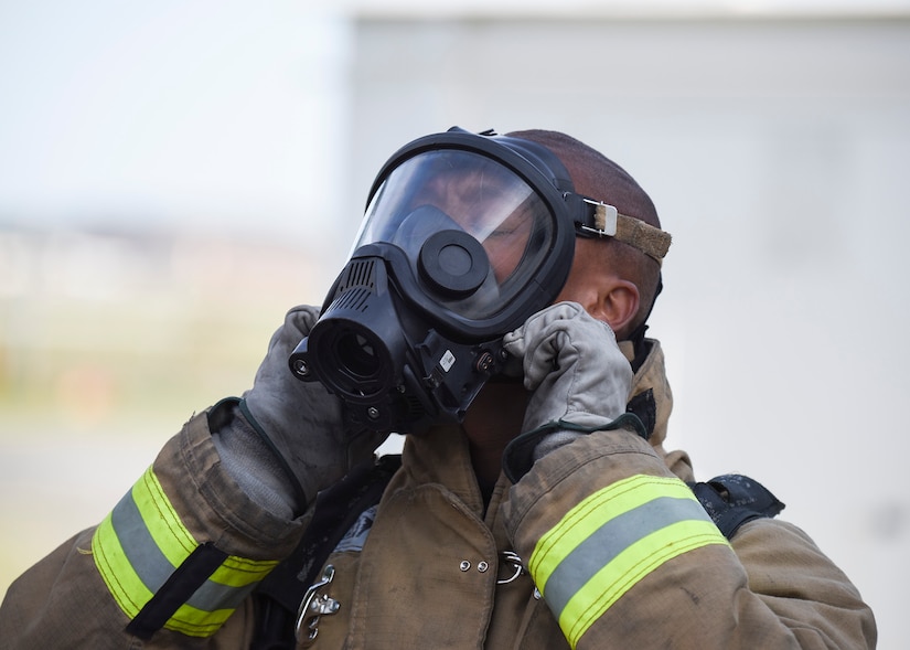 A cadet puts on his firefighting gear before entering the simulated structure fire at Joint Base Andrews, Md., July 30, 2022.