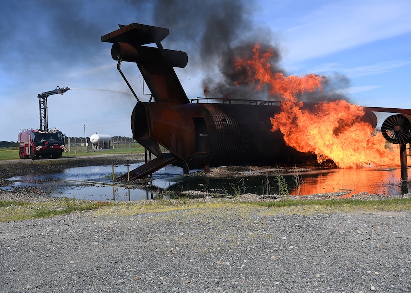 Cadets in the 2022 Fire Explorer Program use a fire truck with a high-rise extension turret during a simulated aircraft fire at Joint Base Andrews, Md., July 30, 2022.